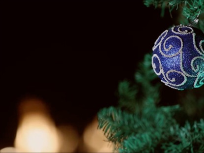 red ornament hanging on a christmas tree wtih black background christmas black background